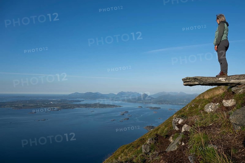 Woman with walking sticks standing on a ledge, Rørsethornet stone stairs, with 3292 steps one of the longest continuous stone stairs in the world, Sherpat stairs or Midsund stairs or Midsundtrappene, Rørsethornet hike, Otroya or Otrøya island, Møre og Romsdal, Norway