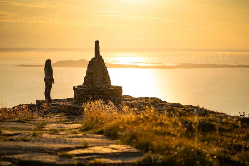 Woman standing next to cairn and looking at the sea, Rørsethornet stone staircase, with 3292 steps one of the longest continuous stone staircases in the world, Sherpat stairs or Midsund stairs or Midsundtrappene, Rørsethornet hike, evening mood, Otroya or Otrøya island, Møre og Romsdal, Norway