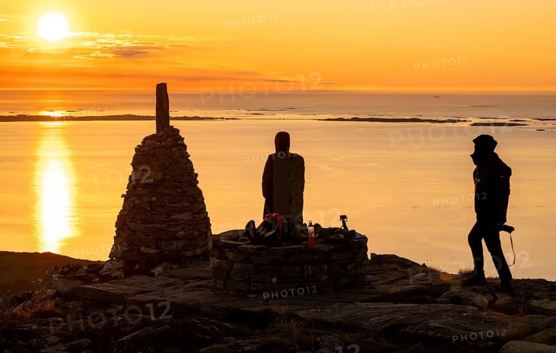 Silhouettes of two hikers next to cairns at sunset, Rørsethornet stone staircase, with 3292 steps one of the longest continuous stone staircases in the world, Sherpatreppe or Midsundtreppe or Midsundtrappene, Rørsethornet hike, Otroya or Otrøya island, Møre og Romsdal, Norway