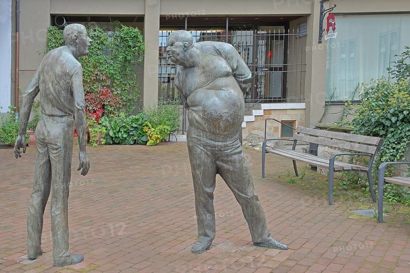 Sculpture Confrontation by Karl-Henning Seemann 1979, two bronze sculptures, modern art, male figures, life-size, social non-verbal communication, fierce facial expression, evil eye, interaction, gesture, emotion, posture, conflict, dispute, quarrel, argument, grim, angry, furious, serious, look, Am Markt, Tübingen, Neckartal, Baden-Württemberg, Germany