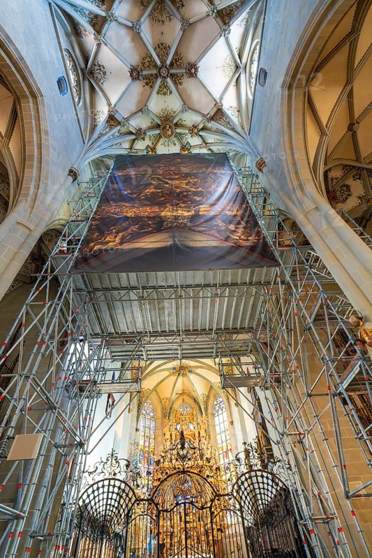 Magnificent church interior with scaffolding and golden decorations, covered by a painted banner, St Nicholas Minster, Überlingen, Lake Constance, Germany