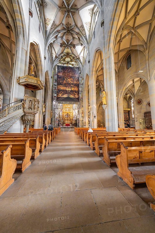 Gothic church with detailed construction, wooden benches and large painted banner above the altar area, St Nicholas Minster, Überlingen, Lake Constance, Germany