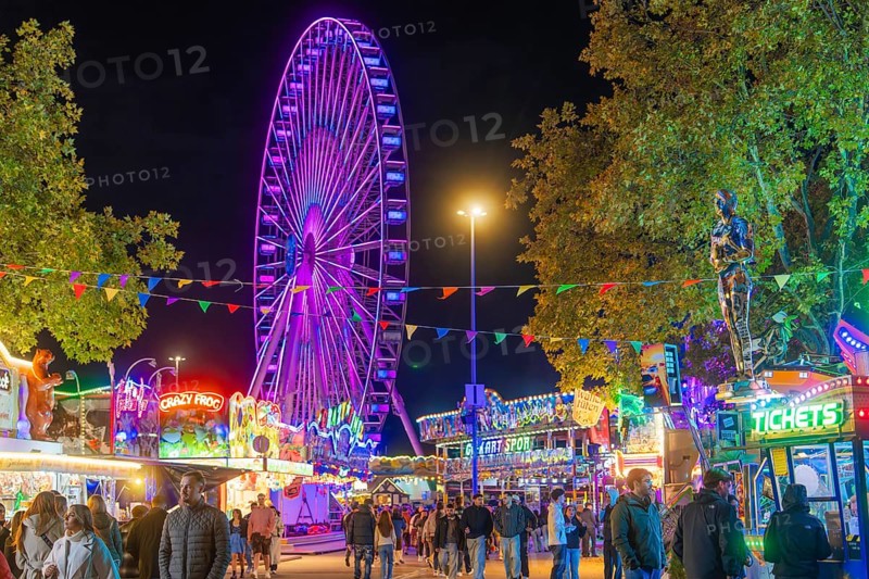 Lively scenery with colourful lights and a large Ferris wheel, Cannstatter Wasen folk festival, Stuttgart, Germany