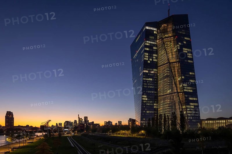 The lights of the European Central Bank (ECB) and the Frankfurt banking skyline glow in the evening, Frankfurt am Main, Hesse, Germany