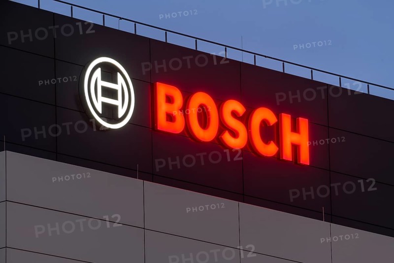 Illuminated Bosch logo on a grey façade against a blue night sky, Waiblingen, Baden-Württemberg, Germany