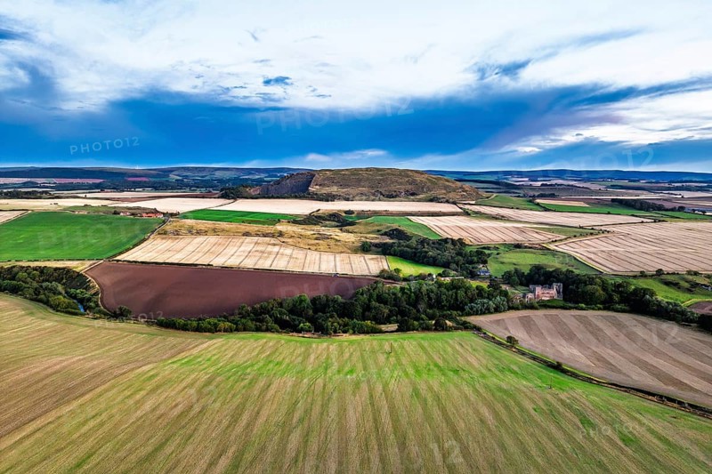 Sunset of Fields and Farms over Traprain Law and Hailes Castle from a drone, River Tyne, Haddington, East Lothian, Scotland, UK