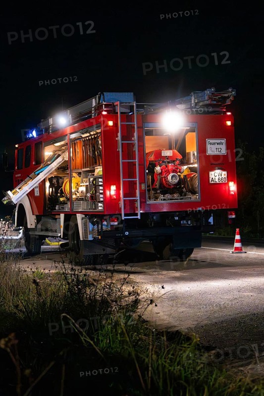 Fire engine at night with open back, illuminated by lanterns and blue lights, fire brigade exercise in the new tunnel of the Hermann Hesse railway, Ostelsheim, district of Calw, Germany