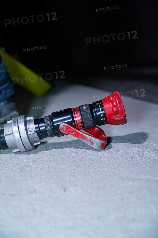 Close-up of a fire hose with a red nozzle on the ground, fire drill in the new construction tunnel of the Hermann Hesse railway, Ostelsheim, district of Calw, Germany