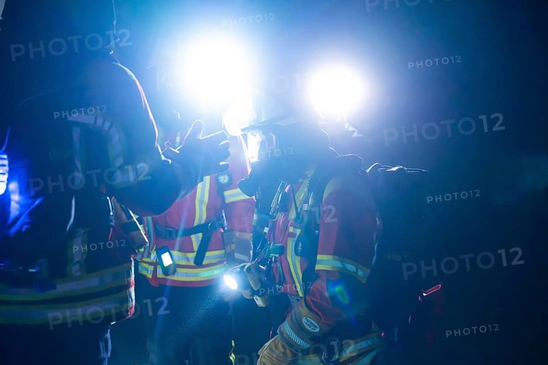 Firefighters illuminated with glare lights, in protective suits, on duty at night, firefighting exercise in the new construction tunnel of the Hermann Hesse railway, Ostelsheim, district of Calw, Germany