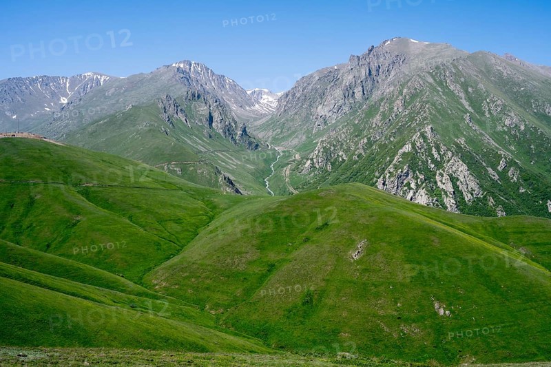 Green hills and majestic mountains under a clear blue sky, at the highest pass in Armenia, Meghri Pass, Tashtun Pass, Syunik Province, Syunik, Armenia