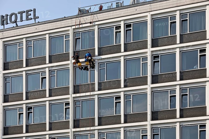 Two male glass cleaners abseiling down the hotel façade to clean windows, aletto Hotel Kudamm, Berlin, Germany