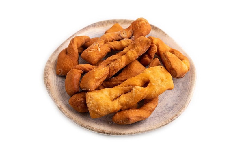 Crunchy biscuit Brushwood cookies sprinkled with powdered sugar isolated on white background, side view, close up