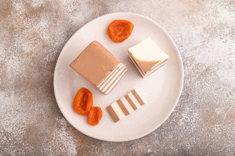 Cocoa and milk jelly with dried apricots on brown concrete background, top view, flat lay, copy space, minimalism