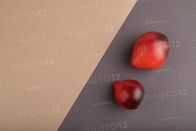 Red Heart shape tomatoes on gray and beige pastel paper background. Top view, copy space, flat lay. healthy food, vegetable, minimalism