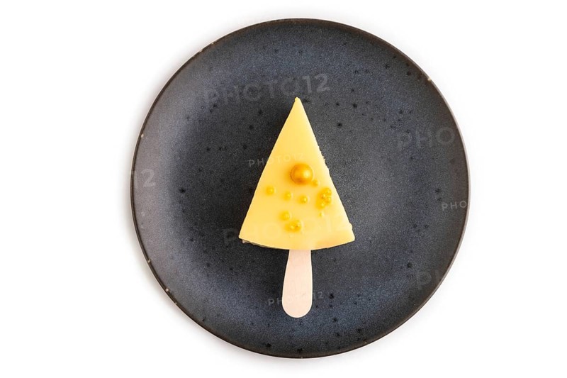 Yellow Cake pop with sprinkles on blue ceramic plate isolated on white background, top view, flat lay, close up, minimalism