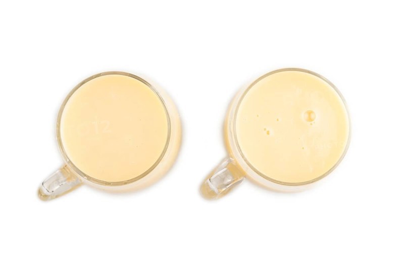 Organic non dairy banana and soy milk in glass isolated on white background. Vegan healthy food concept, flat lay, top view, close up