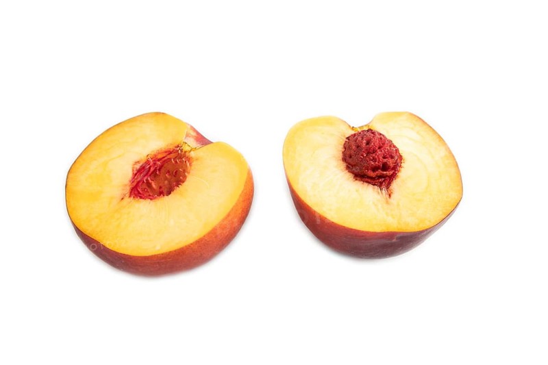 Peach Cut in half isolated on white background. Side view, flat lay, close up. healthy food, vegetable, minimalism