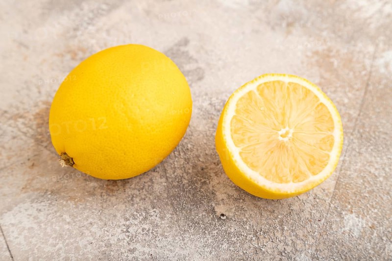 Yellow Lemon Cut in half on brown concrete background. Side view, close up, healthy food, vegetable, minimalism. citrus