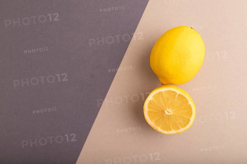 Yellow Lemon Cut in half on beige and gray pastel paper background. Top view, flat lay, copy space. healthy food, vegetable, minimalism