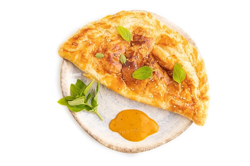 Fried homemade Khachapuri cake with cheese and meat, fried in pan. Traditional Georgian cuisine isolated on white background. Top view, flat lay, close up