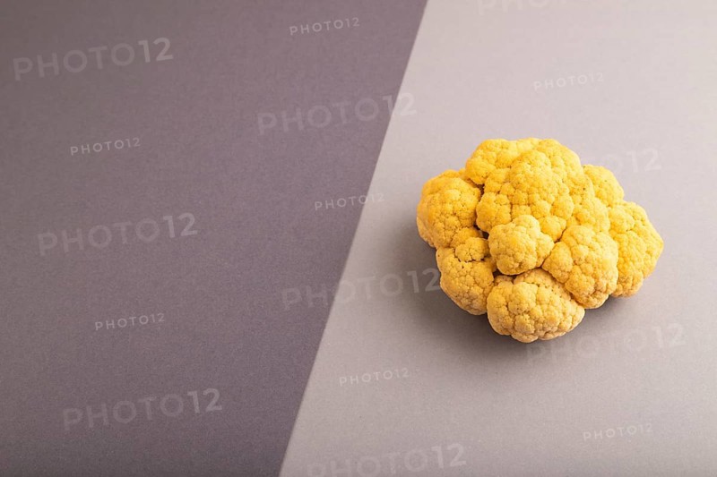 Yellow Cauliflower on black and gray pastel paper background. Side view, copy space. healthy food, vegetable, minimalism