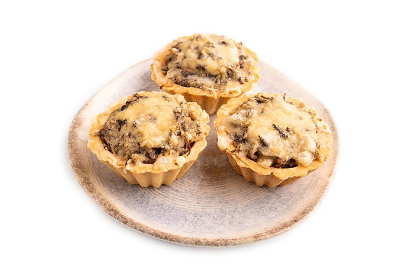 Tartlets with meat and cheese isolated on white background. side view, copy space