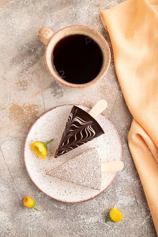 Chocolate and Vanilla Cake pops Marshmallow with cup of coffee on brown concrete background and orange linen textile. top view, flat lay, copy space