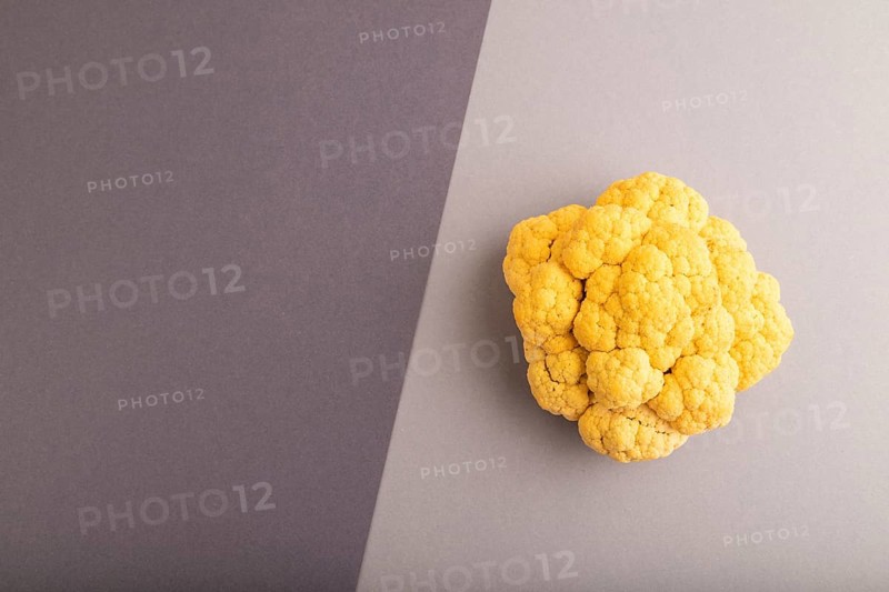 Yellow Cauliflower on black and gray pastel paper background. Top view, flat lay, copy space. healthy food, vegetable, minimalism