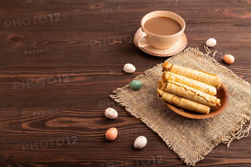 Waffles with caramel on brown wooden background and linen textile, cup of coffee, side view, Copy space
