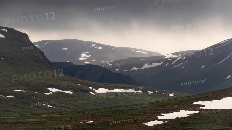 Lonely plateau with snowfields, low clouds, Kongevegen or King's Road, Olavsleden pilgrimage route, Dovrefjell, Oppdal municipality, Trøndelag county, Norway