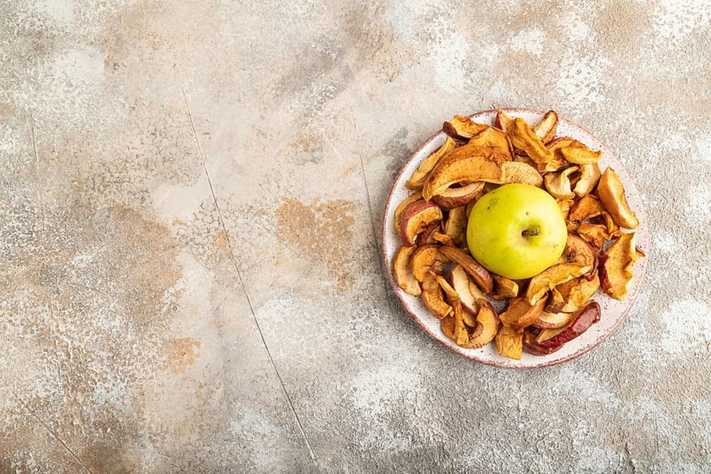 Dried Apples in ceramic bowl on brown concrete background. Top view, copy space, flat lay. healthy food, minimalism. sweet