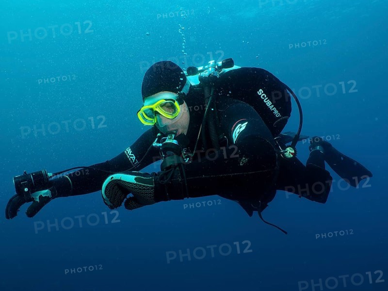 Ein Taucher in voller Ausrüstung kontrolliert unter Wasser seinen Tauchcomputer. Tauchplatz Wrack der Giuseppe Dezza, Pula, Kroatien, Mittelmeer