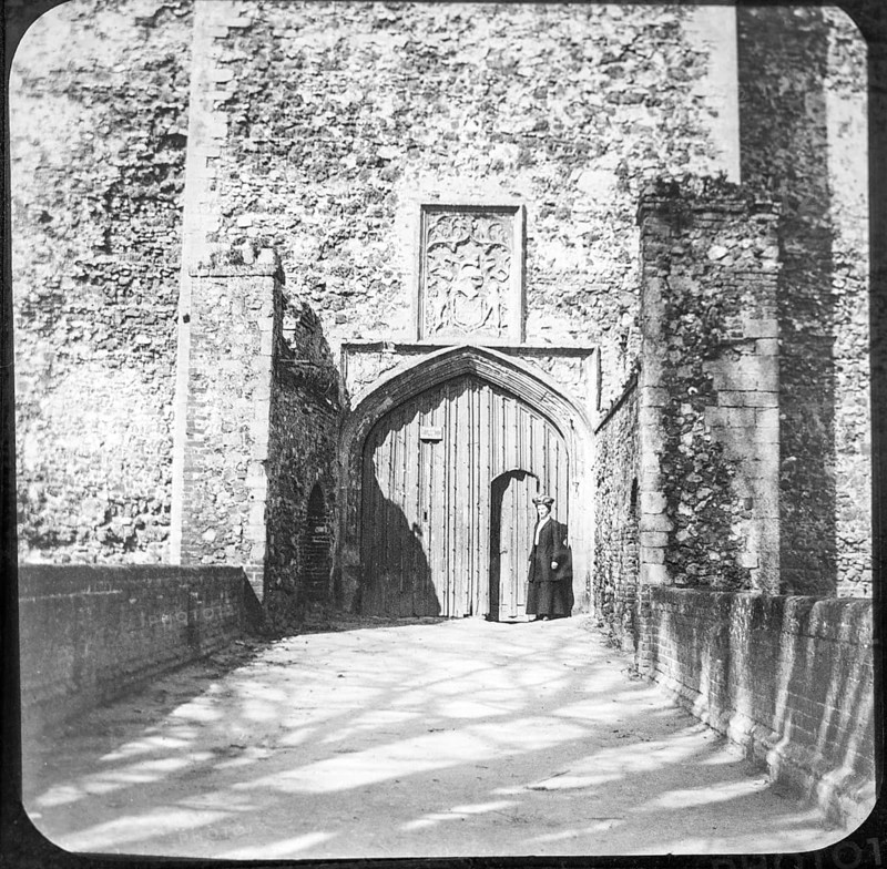 Magic lantern slide of woman standing at doorway entrance to Framingham castle, Suffolk, England, UK c 1910