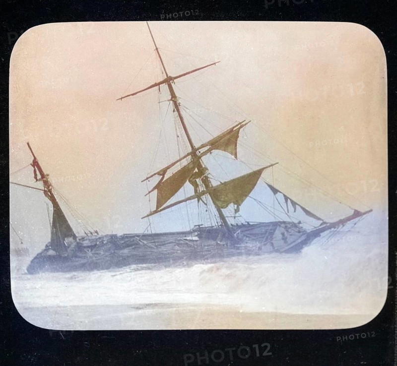 Shipwreck of wooden sailing ship on beach in stormy sea, location unspecified, c 1900 colourised