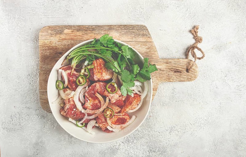 Raw meat marinated with spices and onions, for barbecue, sliced meat, pork neck, in a bowl, homemade, no people