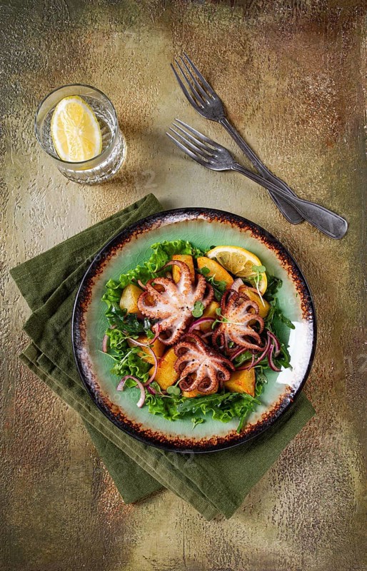 Warm salad, grilled mini octopus, with potatoes and fresh herbs, homemade, no people