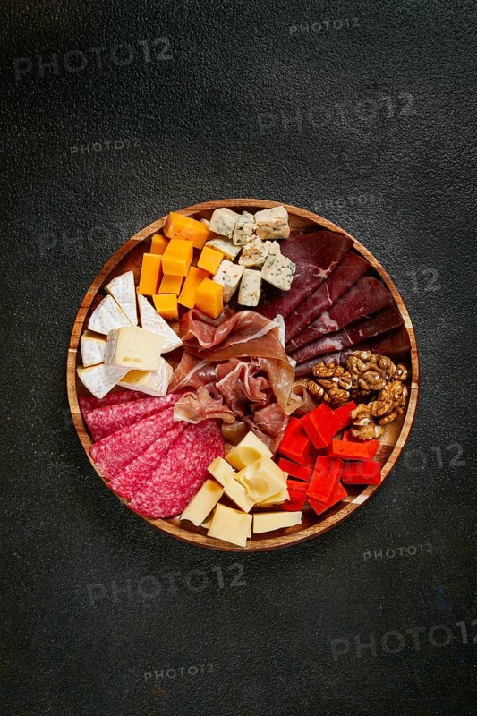 Assortment of cheese meat cuts, on a plate, top view, no people