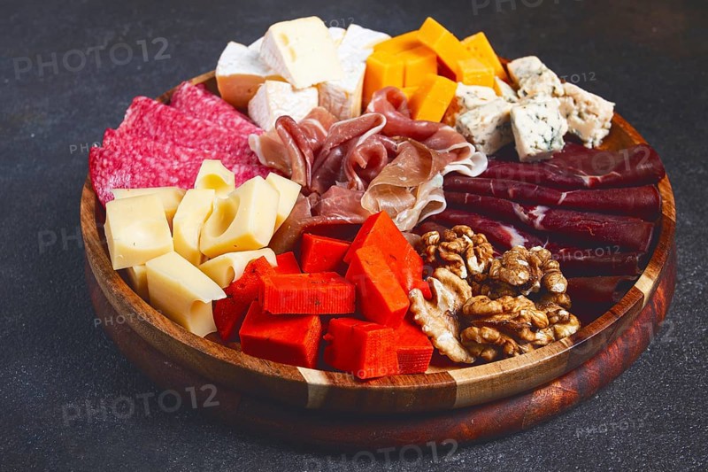Assortment of cheese meat cuts, on a plate, top view, no people