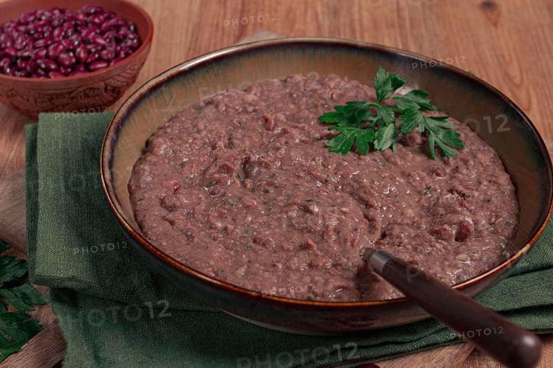 Red bean lobio, a traditional Georgian dish, on a wooden table, homemade