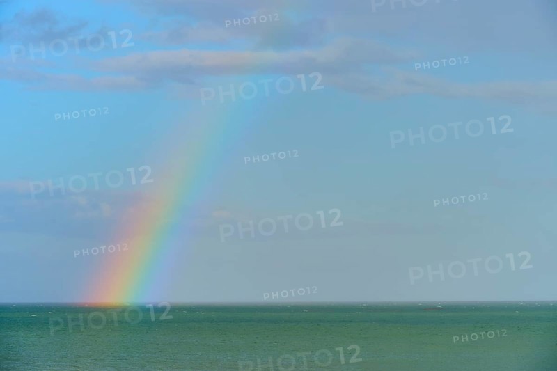 Ein Regenbogen über dem blauen Meer unter einem wolkigen Himmel, Moeraki, Hampden, North Otago, Südinsel, Neuseeland