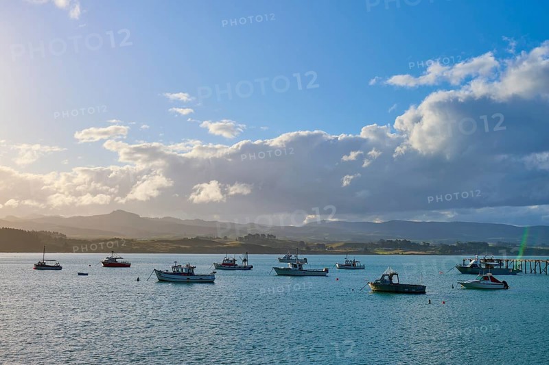 Boote auf einem sonnigen Gewässer mit einer Wolkenlandschaft im Hintergrund, Moeraki, Hampden, North Otago, Südinsel, Neuseeland