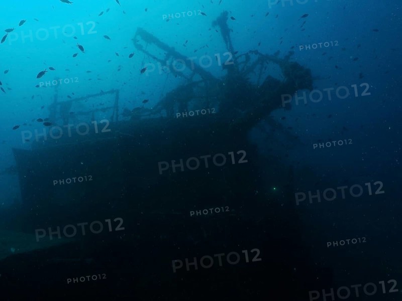 Dark shipwreck, surrounded by a school of fish, dark, mysterious atmosphere. Dive site Wreck of the Vis, Pula, Croatia, Mediterranean Sea