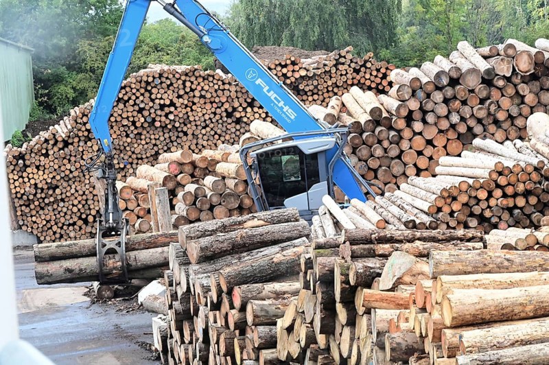 Wood storage and mechanical log transport on the premises of Energie-Mann in the Westerwald. Wood pellets are produced there