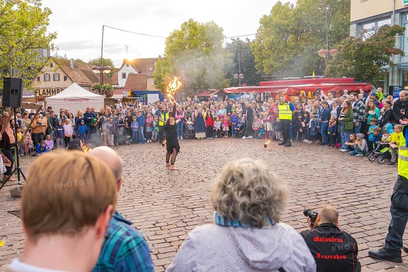 Artist performs a fire show in front of a large crowd at a city festival, Feuernacht, Sindelfingen, Germany