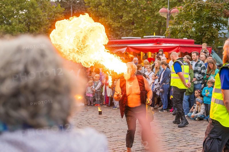 A fire-eater performs an exciting show in front of a large audience on a cobbled street, Feuernacht, Sindelfingen, Germany