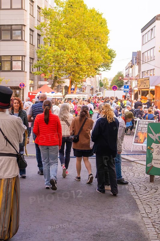 Many people stroll through a busy street at a city festival, trees and colourful clothes characterise the picture, Fire Night, Sindelfingen, Germany