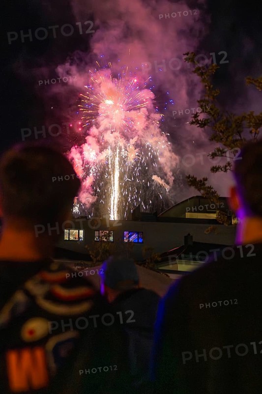 People watching fireworks in the night sky with coloured lights, Fire Night, Sindelfingen, Germany