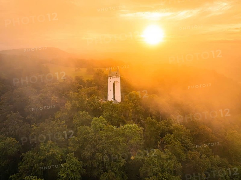 Foggy morning with tower surrounded by trees as the sun rises, Schönberg Tower, Pfullingen, Swabian Alb, Germany