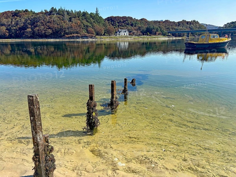 Shoreline landscape with clear water and a yellow boat, calm atmosphere, Silver Sands of Morar, Morar, Scotland, United Kingdom