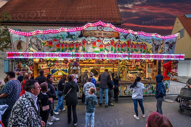 Shooting gallery in the evening at the church fair in the village of Eschenau, Middle Franconia, Bavaria, Germany